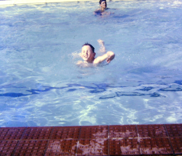 Ein paar Kinder schwimmen in einem mit Wasser gefüllten Pool.