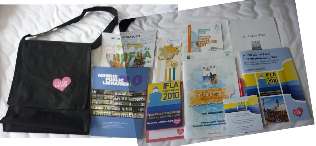 Eine Tasche mit der Aufschrift "Bibliotheksliebhaber" und einige Bücher auf einem Bett.