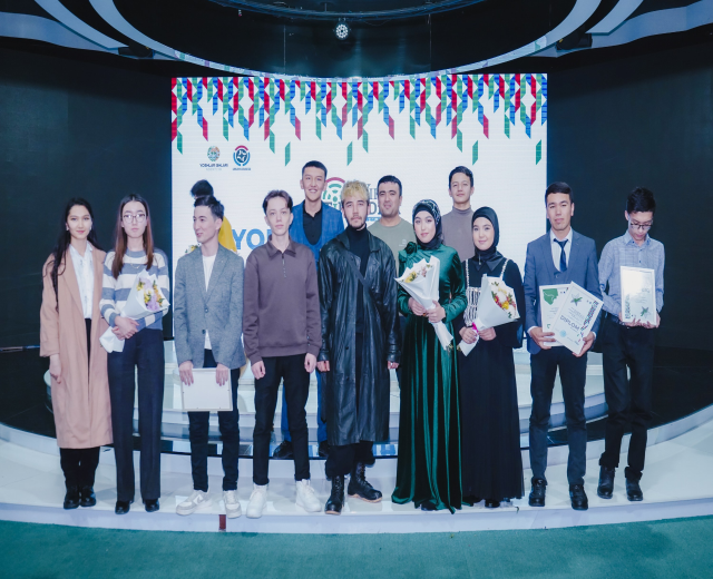 Eine Gruppe von Menschen auf einer Bühne mit Blumensträußen und Urkunden, mit einem Hintergrund, auf dem "Jugend-Solar-Awards 2019" steht.