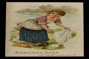 Ein junges Mädchen steht in flachem Wasser, hält einen Lappen und ist von üppiger Vegetation unter einem hellblauen Himmel umgeben, mit dem Text "Sonnenlicht-Seife - Ein Kind kann sie verwenden" unten.