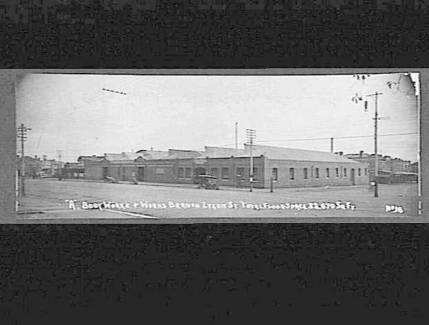 Schwarzes und weißes Foto einer Stadtstraße mit Gebäuden, Strommasten, Kabeln, Fahrzeugen und einem Himmel, mit Text unten, der 'Book House and Works, Bergen, Oregon' lautet.