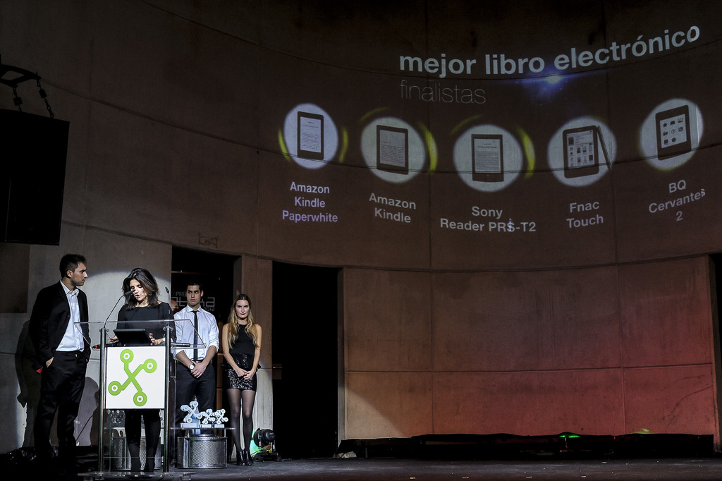 Vier Personen auf der linken Seite, wobei eine Frau ein Seminar hält, und im Hintergrund Bilder von Gadgets mit ihren Namen darunter.