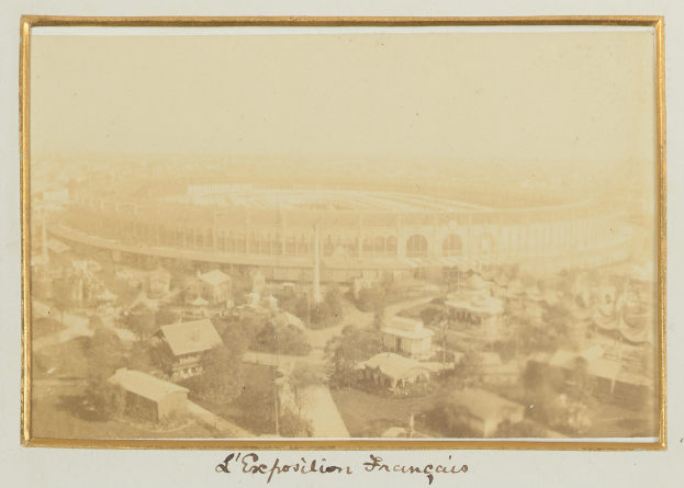 Altes Schwarz-Weiß- Foto eines Stadions, umgeben von Gebäuden, Bäumen und Strommästen mit Text unten.