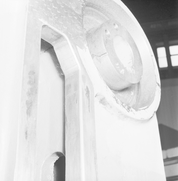 Nahaufnahme einer glänzenden, detailreichen Fräsmaschine in einer Fabrik, mit einer Wand und Fenstern im Hintergrund.